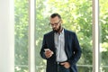 Portrait of handsome mature man in elegant suit with mobile phone Royalty Free Stock Photo