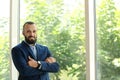 Portrait of handsome mature man in elegant suit near window Royalty Free Stock Photo