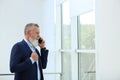 Portrait of handsome mature man in elegant suit talking on mobile phone Royalty Free Stock Photo