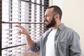 Portrait of handsome mature man looking through window blinds Royalty Free Stock Photo