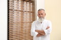 Portrait of handsome mature man near window Royalty Free Stock Photo