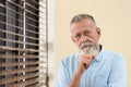 Portrait of handsome mature man near window Royalty Free Stock Photo