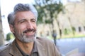 Portrait of handsome mature man on public bench