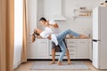 Portrait of handsome man and attractive Caucasian young adult woman having fun together while cooking on the kitchen, romantic Royalty Free Stock Photo