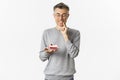 Portrait of handsome middle-aged man in glasses and gray sweater, looking tempted at delicious cake, wanting to eat