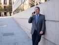 Portrait of handsome middle aged smart businessman walking in the city talking on mobile phone Royalty Free Stock Photo