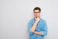 Portrait of handsome minded young man in glasses think