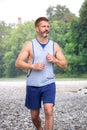 Handsome muscular bearded athlete running outdoors