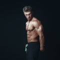 Portrait of a handsome muscular bodybuilder posing over black ba