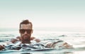 Portrait of a handsome, muscular man relaxing in a warm tropical water