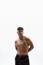 Portrait of handsome, muscular young man posing shirtless in pants against white studio background. Vertical image Royalty Free Stock Photo