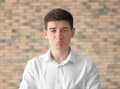 Portrait of handsome offended young man against brick wall Royalty Free Stock Photo