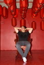 Handsome Persian man sitting and thinking on the chair inside artistic red room Royalty Free Stock Photo
