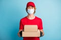 Portrait of handsome postman hands hold carton boxes wear medical cold healthcare mask isolated on blue color background
