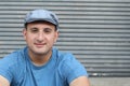 Portrait of handsome real looking man in hat sitting outdoors Royalty Free Stock Photo