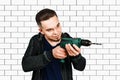 Portrait of a handsome repairman with drill in the bright interior Royalty Free Stock Photo