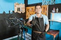 Portrait of a handsome repairman with thumbs up in an apron