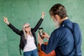 Portrait of handsome senior bearded man taking photo of his pretty woman, posing to camera on green wall background Royalty Free Stock Photo