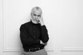 Portrait of handsome senior man against light wall, space for text. Black and white effect Royalty Free Stock Photo