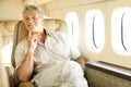 Travelling in style. Portrait of a handsome senior man sitting in an airplane with a smile. Royalty Free Stock Photo