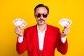 Portrait of handsome serious middle age man playing poker gambling addicted isolated on yellow color background