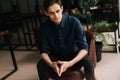 Portrait of handsome serious young business man with pensive expression sitting at the chair. Royalty Free Stock Photo