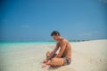 Portrait of handsome sexy young tanned man resting at the beach at the tropical island luxury resort Royalty Free Stock Photo