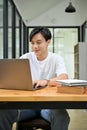 Portrait, Handsome and smart Asian male doing his project, using laptop computer Royalty Free Stock Photo