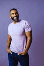 portrait of a handsome smiling african american man with beard and mustache purple shirt on a gray looking away at copy Royalty Free Stock Photo