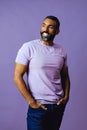 portrait of a handsome smiling african american man with beard and mustache purple shirt on a gray looking away at copy Royalty Free Stock Photo