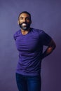 portrait of a handsome smiling man with beard and mustache purple shirt on a gray looking at camera space background Royalty Free Stock Photo