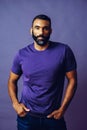 portrait of a handsome smiling man with beard and mustache purple shirt on a gray looking at camera space background Royalty Free Stock Photo