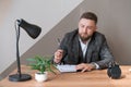 Portrait handsome smiling man with beard, working in office on some project, he Royalty Free Stock Photo