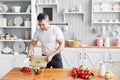 Portrait of handsome smiling man chopping vegetables in the kitchen. The concept of eco-friendly products for cooking. Royalty Free Stock Photo