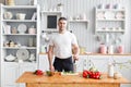 Portrait of handsome smiling man chopping vegetables in the kitchen. The concept of eco-friendly products for cooking. Royalty Free Stock Photo
