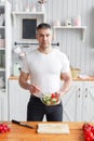 Portrait of handsome smiling man chopping vegetables in the kitchen. The concept of eco-friendly products for cooking. Royalty Free Stock Photo