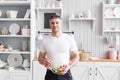 Portrait of handsome smiling man chopping vegetables in the kitchen. The concept of eco-friendly products for cooking. Royalty Free Stock Photo