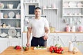 Portrait of handsome smiling man at kitchen. cooking and home concept - close up of male hand chopping cucumber on Royalty Free Stock Photo