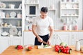 Portrait of handsome smiling man at kitchen. cooking and home concept - close up of male hand chopping cucumber on Royalty Free Stock Photo