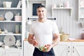 Portrait of handsome smiling man at kitchen. cooking and home concept - close up of male hand chopping cucumber on Royalty Free Stock Photo