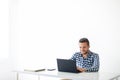 Portrait of handsome smiling man typing on laptop on white background Royalty Free Stock Photo