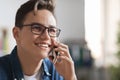 Portrait of handsome smiling young guy wearing eyeglasses talking on mobile phone Royalty Free Stock Photo