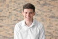 Portrait of handsome smiling young man against brick wall Royalty Free Stock Photo