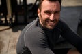 Portrait of handsome sportsman smiling looking at the camera while resting after outdoor workout Royalty Free Stock Photo