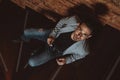 Portrait of a handsome stylish man posing in loft studio interior while lying on wooden stairs. Fashion for men Royalty Free Stock Photo