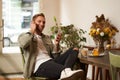 Portrait of handsome, stylish young man, cafe visitor, sitting with his smartphone and listening to music in wireless Royalty Free Stock Photo