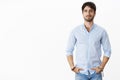 Portrait of handsome successful male entrepreneur in stylish shirt smiling self-assured standing in confident pose with