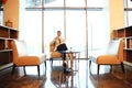 Portrait of handsome successful man drink coffee sitting in coffee shop, business man having breakfast at hotel lobby. Royalty Free Stock Photo