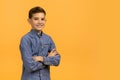 Portrait Of Handsome Teen Boy With Folded Arms Standing Over Yellow Background Royalty Free Stock Photo