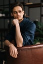 Portrait of handsome thoughtful young business man with pensive expression sitting at the chair Royalty Free Stock Photo